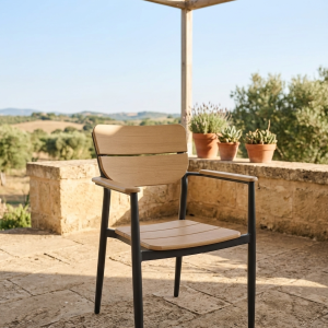 Moderni vrtni stol Oslo z aluminijastim ogrodjem in letvicami iz umetnega lesa na urejeni terasi z vrtom.